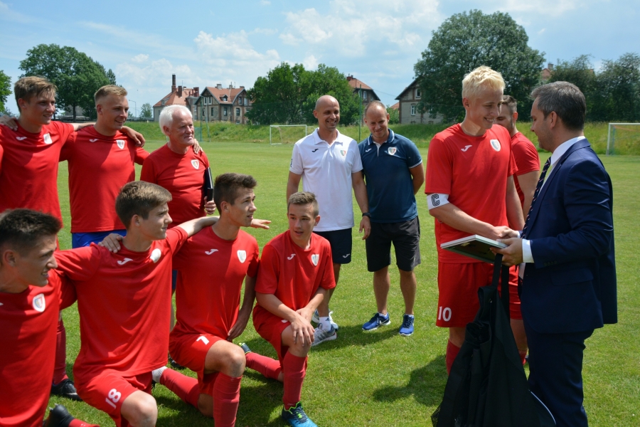 Przedstawiciel Śląskiego Związku Piłki Nożnej Tomasz Kulczycki gratuluje juniorom młodszym Piasta Gliwice mistrzostwa